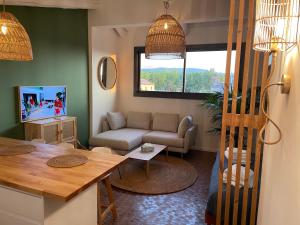 ein Wohnzimmer mit einem Sofa und einem Tisch in der Unterkunft sous les toits de st tropez in Saint-Tropez