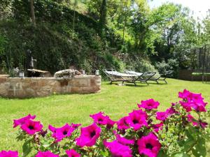 a group of pink flowers in a yard with a bench at Les Gîtes du Moulin d Olt in La Canourgue