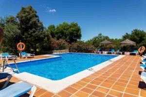 uma piscina com espreguiçadeiras e um resort em El Horcajo em Montecorto