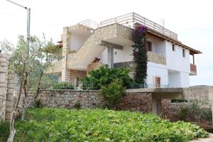 una casa en la parte superior de una pared de piedra en Pellumb Apartments, en Ksamil