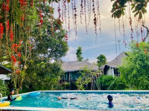 a swimming pool with people in the water at บ้านริมเลปากประ Banrimlay Pakpra in Phatthalung