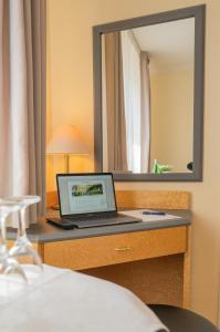 een laptop op een bureau in een hotelkamer bij Hotel Waghäuseler Hof GmbH in Waghäusel