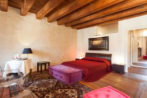 een slaapkamer met een rood bed en een tafel bij Truly Verona - Delle Erbe suites in Verona