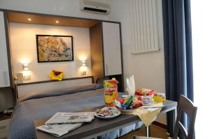 una habitación de hotel con una cama y una mesa con comida. en Hotel Puntabella, en Varazze