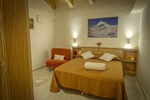 a bedroom with a bed and a chair and a mountain at PaeseMio Cervarezza in Cervarezza