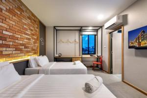 Postel nebo postele na pokoji v ubytování PLAAI Plus Hotel Rayong