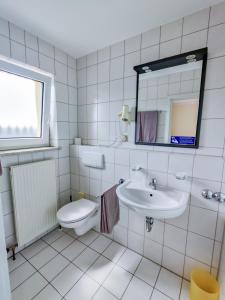 a white bathroom with a sink and a toilet at Hotel Waghäuseler Hof GmbH in Waghäusel