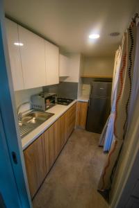 a small kitchen with a sink and a refrigerator at HILLS RESORT Beach, Bungalows and Bar - Velika Plaza Ulcinj in Ulcinj