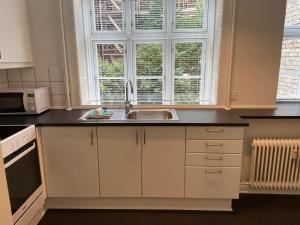 a kitchen with white cabinets and a sink and a window at Næstvedgade in Copenhagen