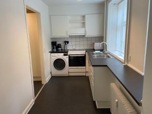 a kitchen with a washing machine and a washer and dryer at Næstvedgade in Copenhagen