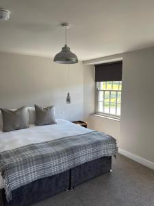 a bedroom with a bed and a window at The Tavern at Hale in Milnthorpe