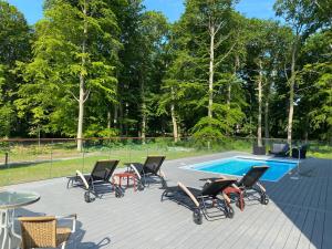 a deck with chairs and a swimming pool at Best Western Valhall Park Hotell in Ängelholm