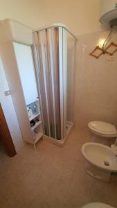 a bathroom with a toilet and a glass shower at Villa leone 2 in Pisticci +43 photos
