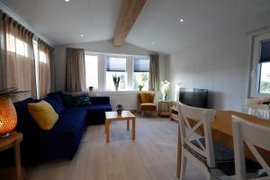 un soggiorno con un divano blu e un tavolo di 11-stedenchalet Hindeloopen - Nr. 47 a Molkwerum