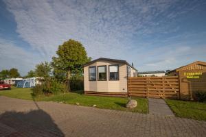 a tiny house in a yard next to a fence at 11-stedenchalet Hindeloopen - Nr. 47 in Molkwerum