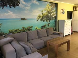 ein Wohnzimmer mit einem großen Gemälde des Ozeans in der Unterkunft Apartament Hania - Krynica Morska in Krynica Morska