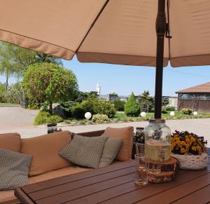 an umbrella sitting on a wooden table with a couch at Agroturystyka "U Sochy" in Ramleje