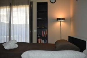 1 dormitorio con cama, lámpara y estante para libros en Apartamento Arenys de Munt - Costa Barcelona, Maresme -, en Arenys de Munt