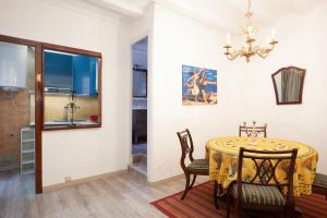 巴塞隆納的住宿－埃斯基羅爾公寓，一间带桌椅和吊灯的用餐室