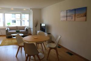 una sala de estar con una mesa, sillas y un sofá en Salt&Sea, en Middelkerke
