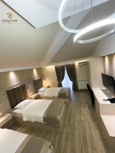 Habitación de hotel con 2 camas y escritorio en Hotel Holiday, en Podgorica