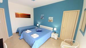 a blue bedroom with a bed and a chair at B&B Colori del Salento in Presicce