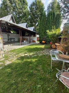 a backyard with a table and chairs and a building at Camere de inchiriat Cascada in Buşteni