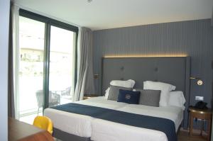 um quarto com uma cama grande e uma janela grande em Hotel Lima - Adults Recommended em Marbella