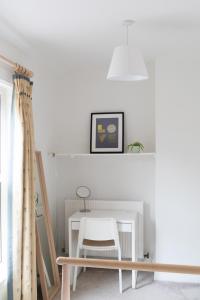 a white room with a chair and a table at Victorian end-of-terrace, Boston Spa in Boston Spa