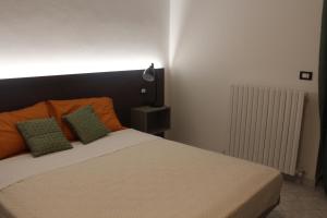 a bedroom with a bed with orange and green pillows at La casa del Sole in Fermo