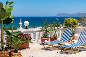 two chairs on a balcony with the ocean in the background at Kurmulis Studios in Stalos