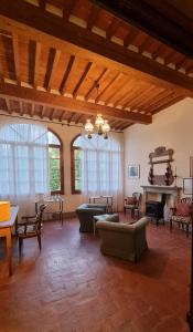 una sala de estar con sofás, mesas y ventanas en Bella di Ceciliano, en Arezzo