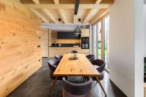 a kitchen and dining room with a wooden table and chairs at Hiša Križaj in Bohinj