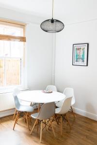 a white dining room with a white table and chairs at Victorian end-of-terrace, Boston Spa in Boston Spa