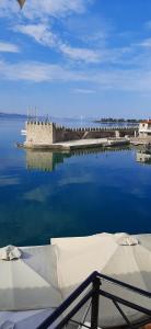 a boat in the water with a castle in the water at Dr. J. Spon Apartment in Nafpaktos