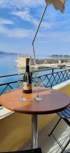 a table with two glasses and a bottle of wine at Dr. J. Spon Apartment in Nafpaktos