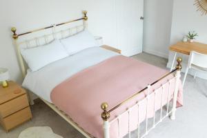 a bedroom with a bed with a pink blanket at Victorian end-of-terrace, Boston Spa in Boston Spa