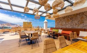 a rooftop restaurant with tables and chairs and a view at DWO Nopal in Puerto de la Cruz