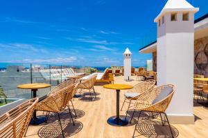 a patio with chairs and tables on a roof at DWO Nopal in Puerto de la Cruz