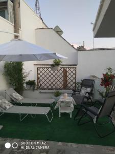 a patio with a table and chairs and an umbrella at Appartamenti La Gina & La Palmira in Otranto