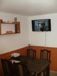 a dining room with a table and a television on the wall at Chata pod Lysou Horou in Ostravice