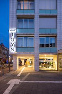un grand bâtiment avec un panneau devant lui dans l'établissement JOYN Cologne - Serviced Apartments, à Cologne