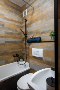 a bathroom with a toilet and a wooden wall at Apartament Eliza in Warsaw