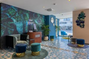 eine Lobby mit einem Wartebereich mit blauen und grünen Wänden in der Unterkunft JOYN Cologne - Serviced Apartments in Köln