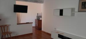 a living room with a television and a chair at Il pergolato in Bari Sardo