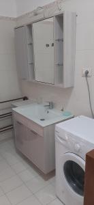 a white bathroom with a washing machine and a sink at Il pergolato in Bari Sardo