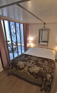 een slaapkamer met een bed en een groot raam bij La Table in Parijs