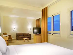 فندق نوفوتيل 6 اكتوبر في السادس من أكتوبر: غرفه فندقيه بسرير واريكه وتلفزيون
