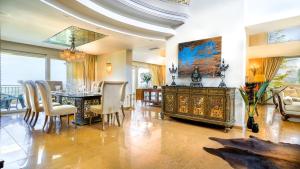 Luxury Villa Allure في Dhafnés: غرفة طعام مع طاولة وكراسي وغرفة بها