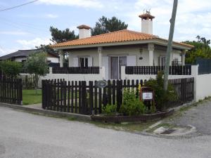 een wit huis met een hek ervoor bij O refúgio - The shelter in Esmoriz